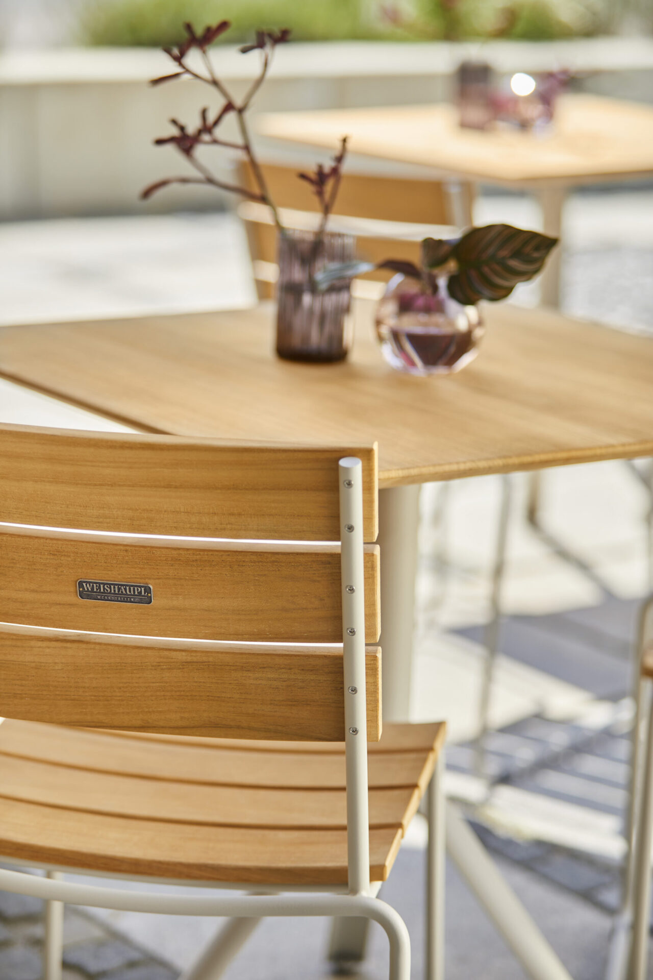 Gartenstuhl von hinten mit Tisch im Hintergrund